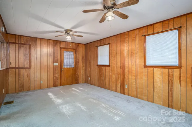 a view of an empty room with closet and a window