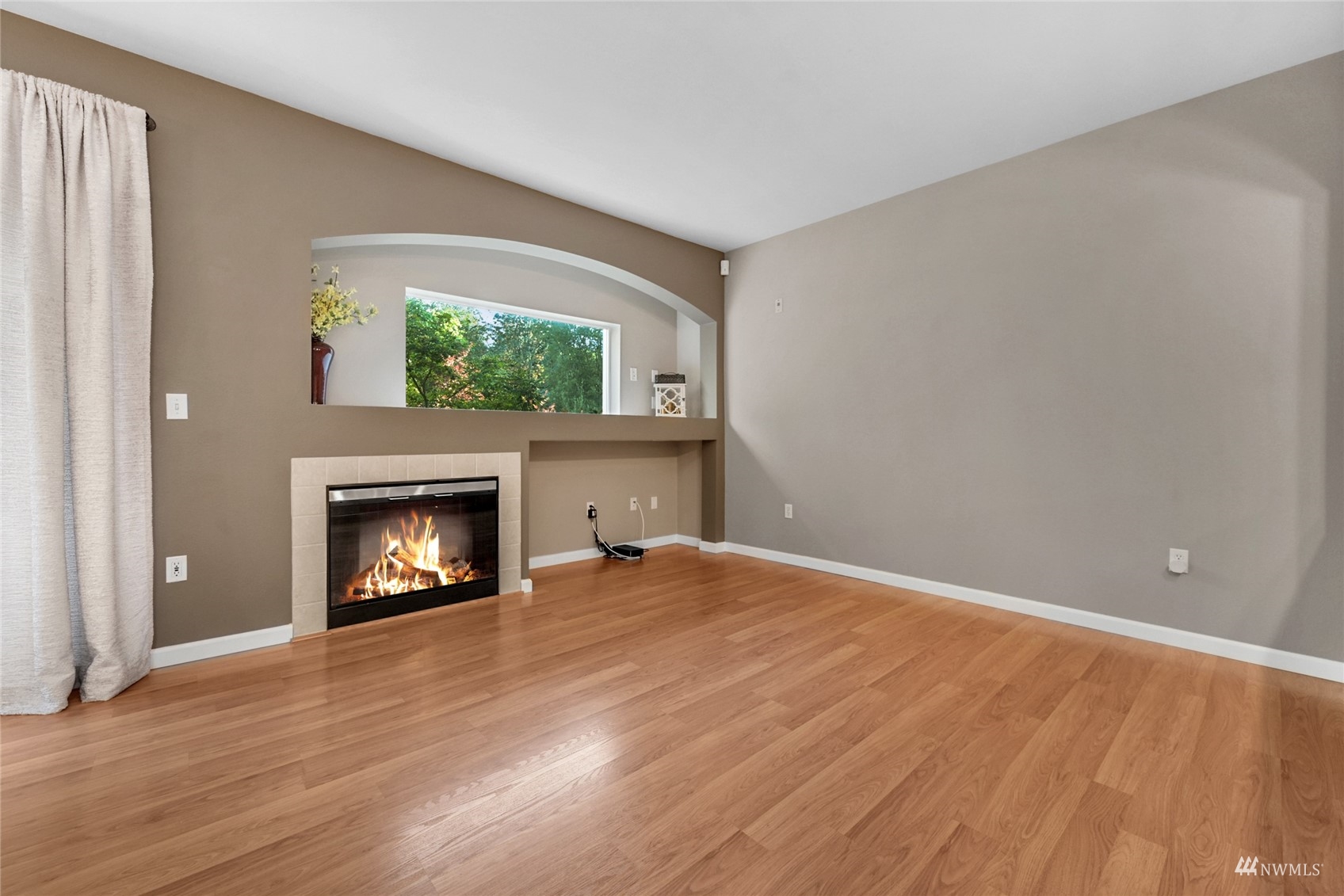 14335 Simonds Road Northeast, Unit A302 Kirkland, WA 98034 - Photo 4 of 25 a view of an empty room with a fireplace and a window