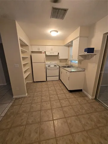 a view of a kitchen with furniture and electronic appliances