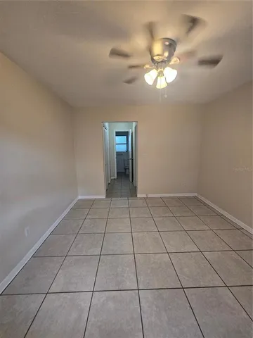 a view of an empty room with a chandelier fan