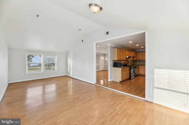 a view of a hallway with wooden floor and a cabinet