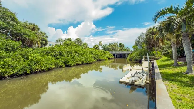 a view of a lake with lawn chairs and a table