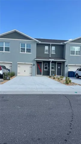 a front view of a house with a yard and parking