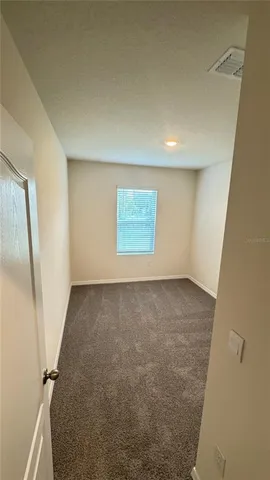 an empty room with mirror and stairs