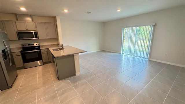 a kitchen with stainless steel appliances a stove a sink a microwave a counter top space and cabinets