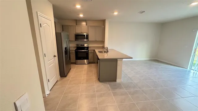 a kitchen with stainless steel appliances a refrigerator a stove a microwave and a sink