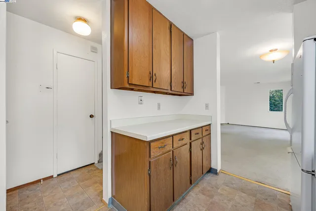 a kitchen with a sink a refrigerator and windows