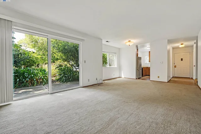 a view of an empty room with a window and fireplace