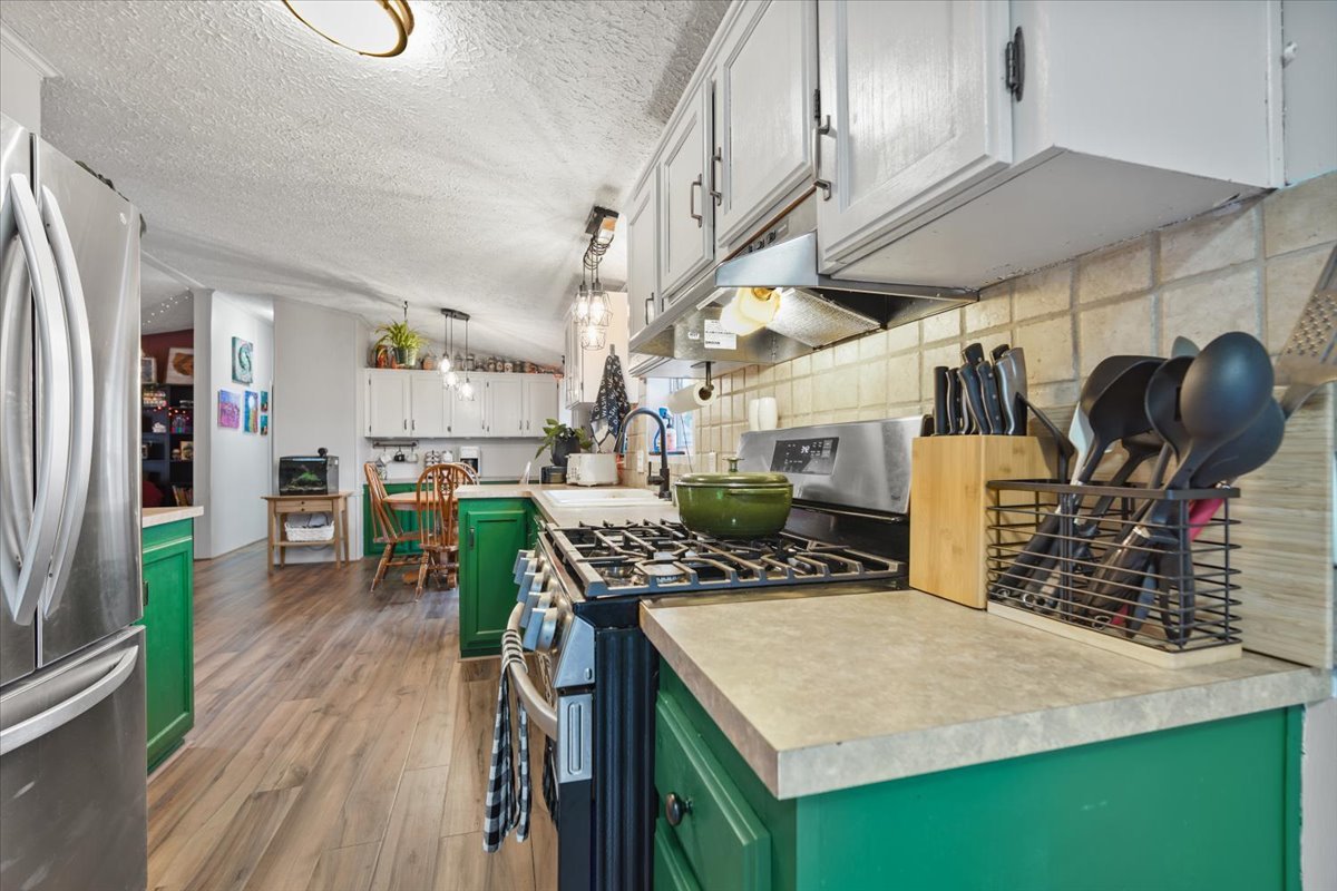 602 West 6th Street Minonk, IL 61760 - Photo 10 of 32 a kitchen with stainless steel appliances kitchen island granite countertop a table chairs and a refrigerator