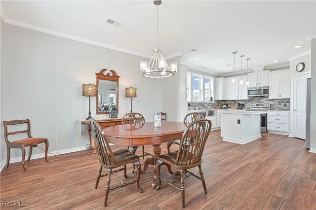 a view of a dining room with furniture a chandelier and wooden floor