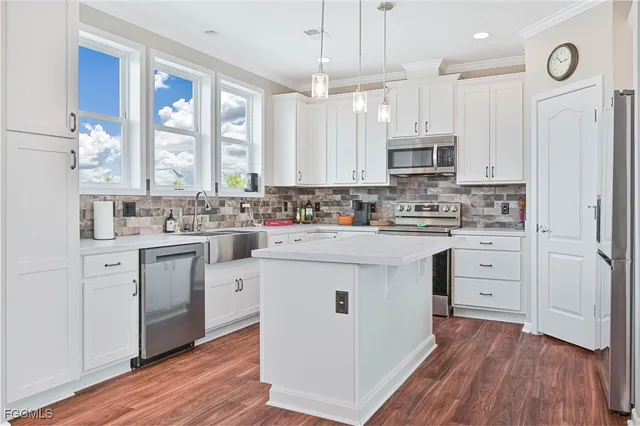 a kitchen with white cabinets sink and stainless steel appliances