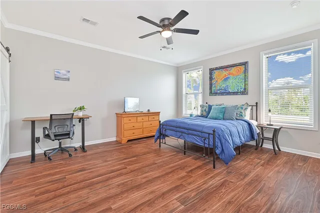 a bedroom with a bed table two chairs and a window
