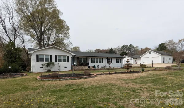 a front view of a house with a yard and trees