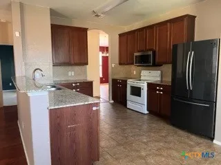 a kitchen with stainless steel appliances granite countertop a refrigerator stove a sink and dishwasher