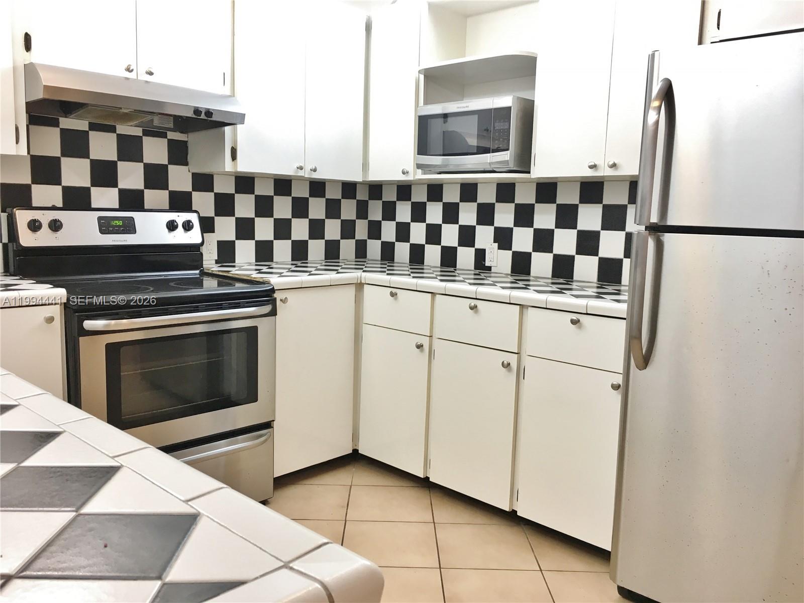 5831 Southwest 62nd Street, Unit WEST Miami, FL 33143 - Photo 2 of 16 a kitchen with cabinets and appliances