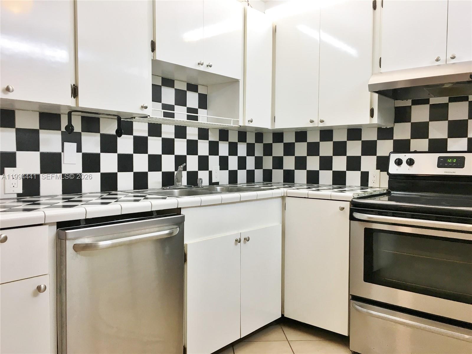 5831 Southwest 62nd Street, Unit WEST Miami, FL 33143 - Photo 6 of 16 a kitchen with a sink a stove and cabinets