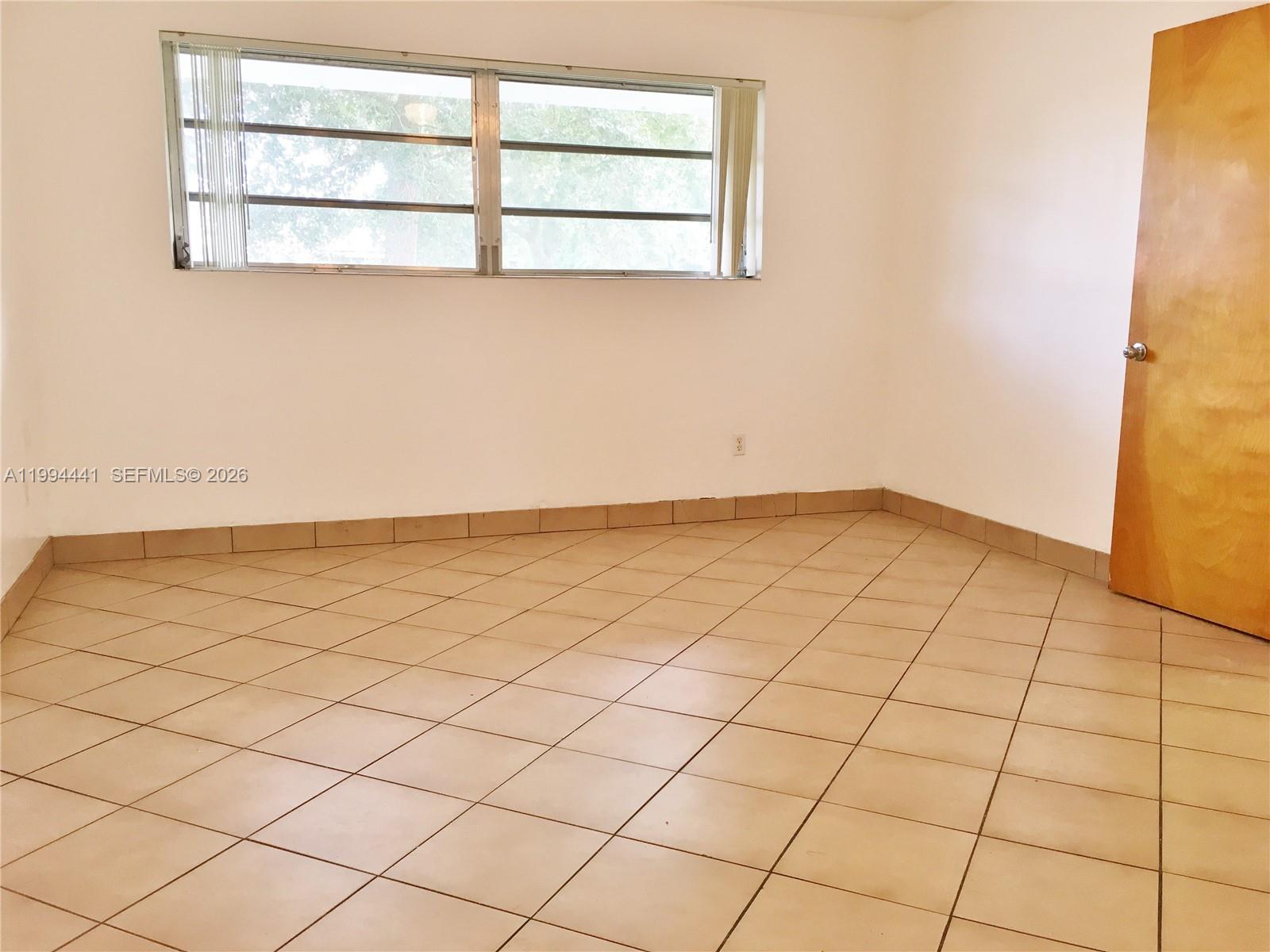 5831 Southwest 62nd Street, Unit WEST Miami, FL 33143 - Photo 8 of 16 an empty room with a window