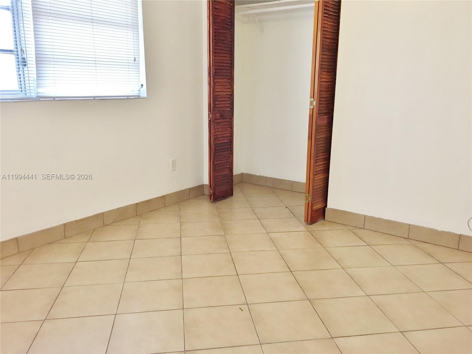 5831 Southwest 62nd Street, Unit WEST Miami, FL 33143 - Photo 9 of 16 a view of an empty room and a window