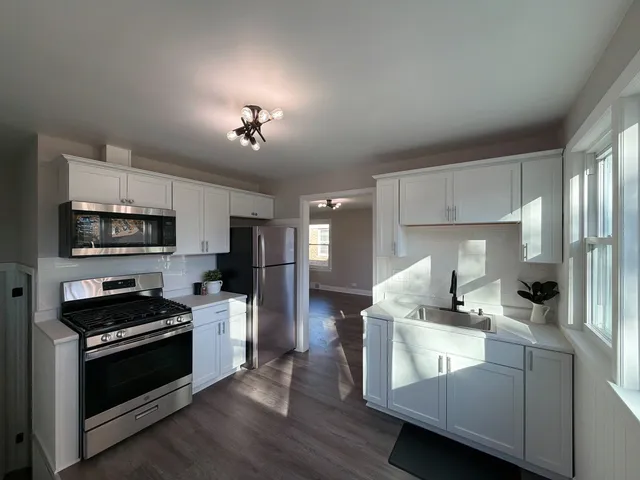 a view of kitchen with sink microwave and cabinets
