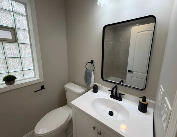 a bathroom with a sink and mirror with toilet