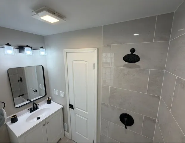 a bathroom with a sink vanity and mirror