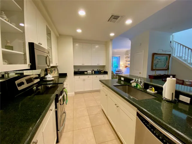 a kitchen with a sink counter top space appliances and cabinets