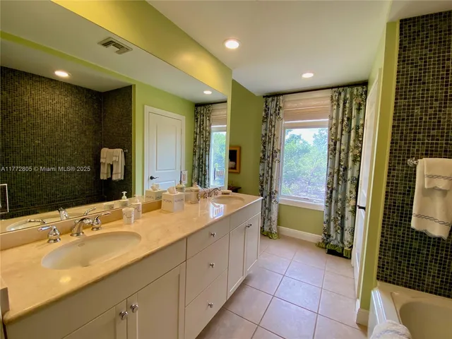 a bathroom with a double vanity sink and a mirror