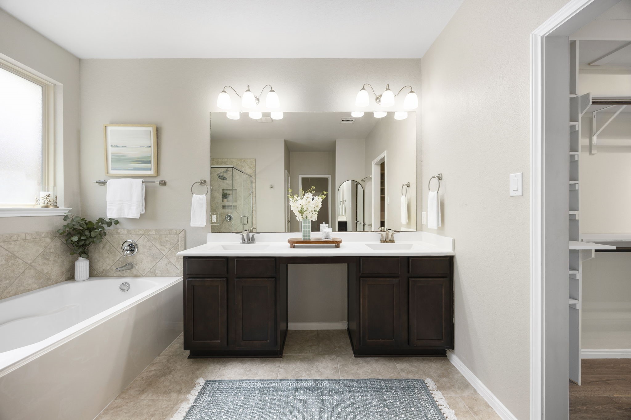 14023 Beaverhead Range Court Conroe, TX 77384 - Photo 16 of 30 Indulge in a spa-like retreat in the expansive primary bathroom. This well-appointed space offers a perfect balance of functionality and relaxation, ensuring a serene start and end to your day. Dual vanities, large mirror, separate tub and shower, frosted window, and elegant finishes complete this spa-like bathroom.