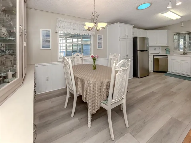 a kitchen with granite countertop white cabinets white stainless steel appliances with a sink and dishwasher