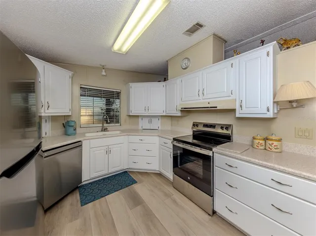a spacious bedroom with a bed and a chandelier