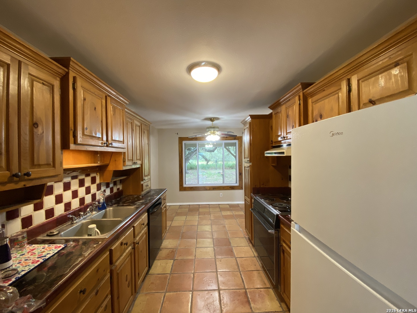 60 Wisdom Road Pleasanton, TX 78064 - Photo 23 of 29 a kitchen with wooden cabinets and a stove top oven