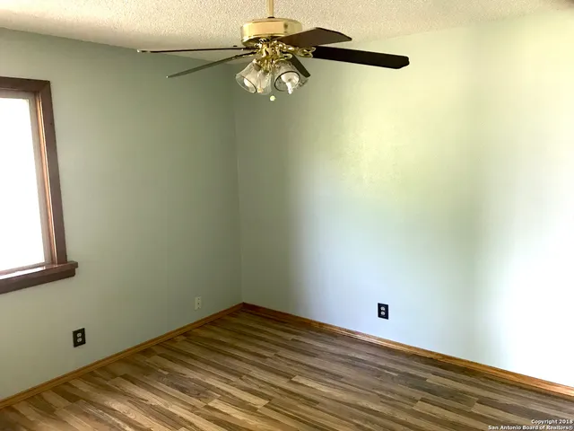 a view of a room with wooden floor and fan