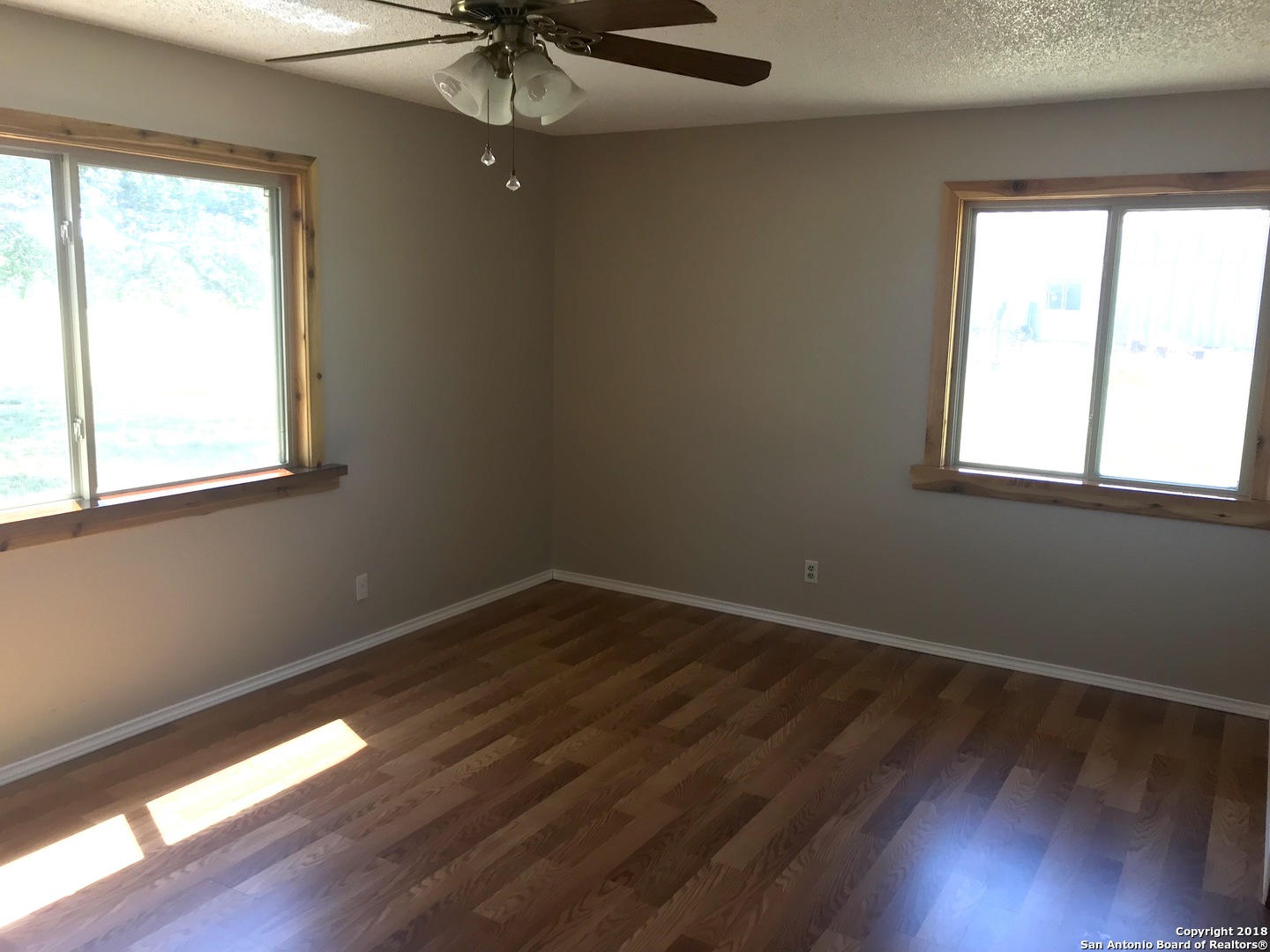 60 Wisdom Road Pleasanton, TX 78064 - Photo 7 of 29 a view of an empty room with wooden floor and a window