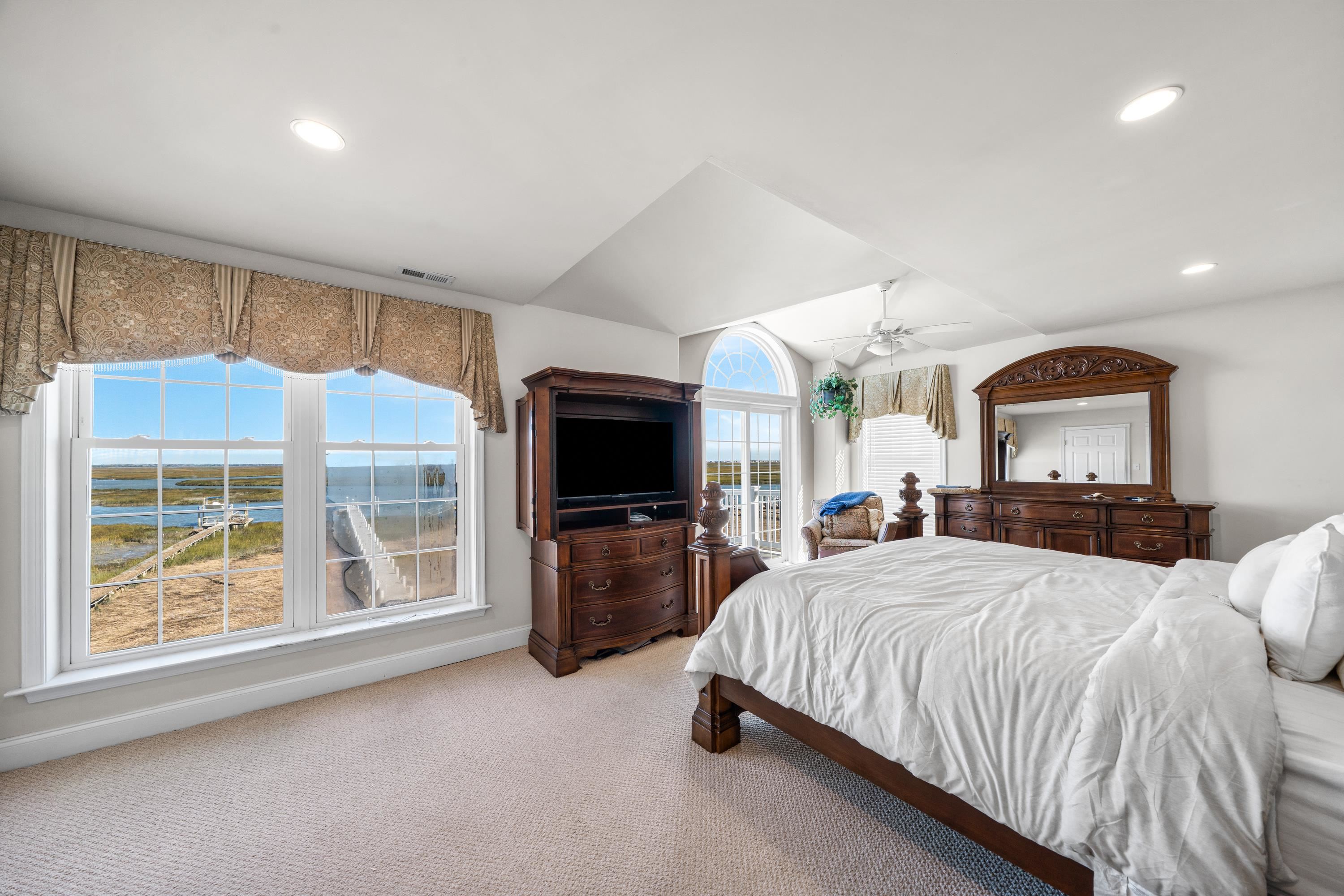 448 Avalon Avalon, NJ 08202 - Photo 14 of 32 a bedroom with a large bed and flat tv screen on dresser