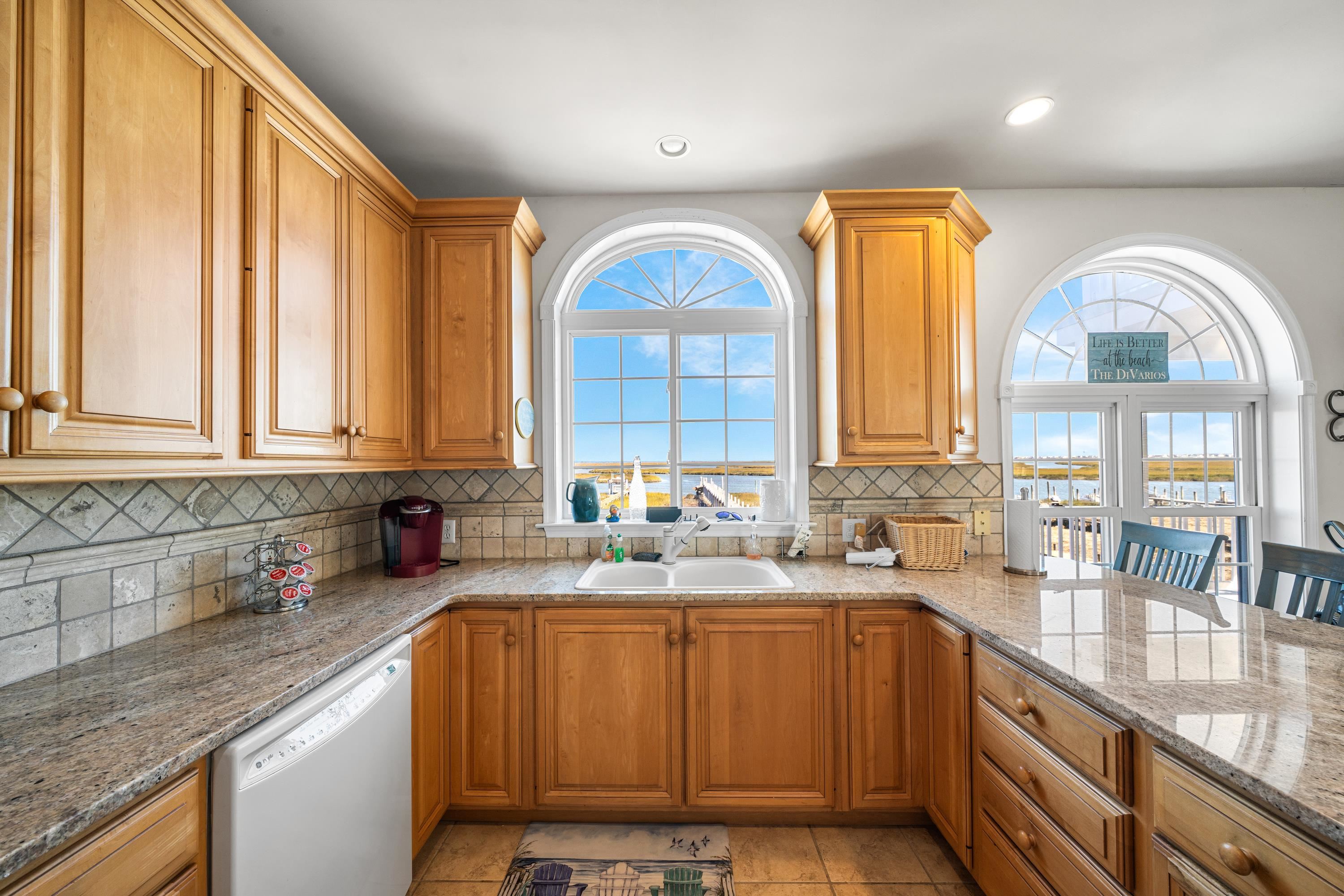 448 Avalon Avalon, NJ 08202 - Photo 4 of 32 a kitchen with stainless steel appliances a sink a stove cabinets and a large window