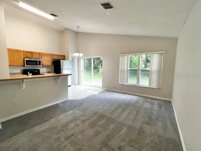 a kitchen that has a sink and a view of living room