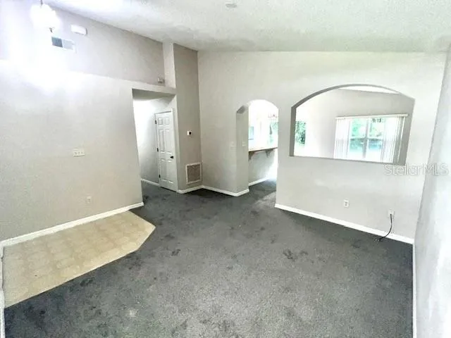 a view of a big house with a street and large trees