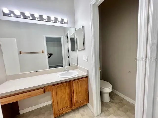 a spacious bathroom with a granite countertop sink a toilet and a mirror
