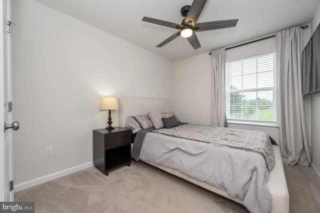 a bedroom with a bed and a ceiling fan
