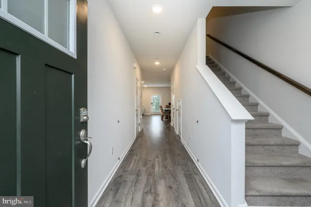 a view of a hallway with wooden floor and staircase