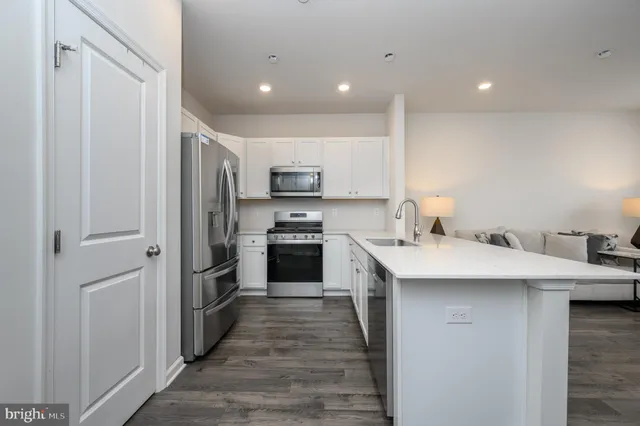 a kitchen with stainless steel appliances a sink stove refrigerator and cabinets