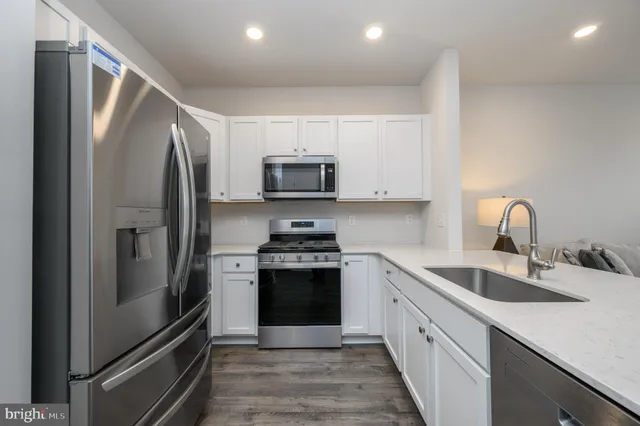 a kitchen with stainless steel appliances granite countertop a refrigerator sink and stove