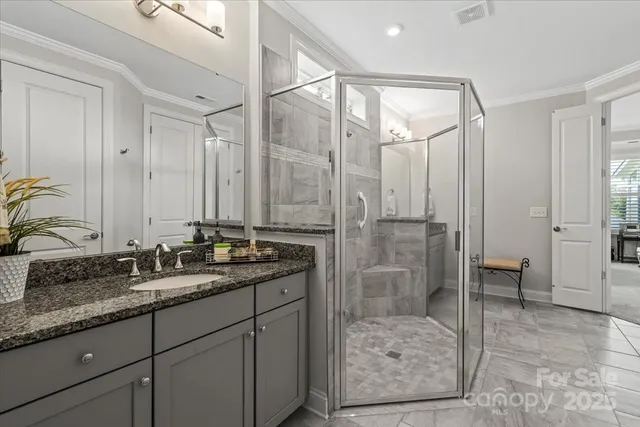 a bathroom with a granite countertop sink a toilet and shower