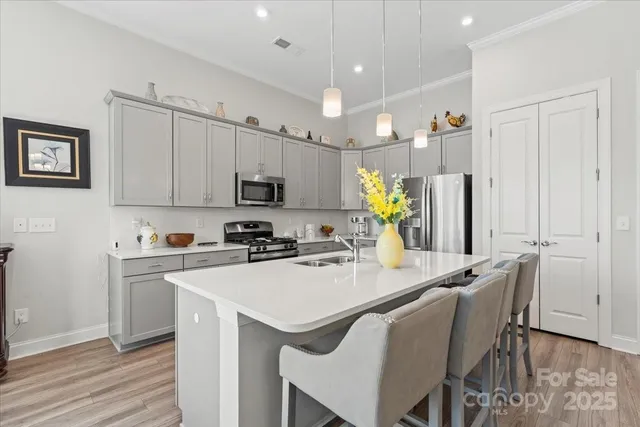 a kitchen with stainless steel appliances a white table chairs and a refrigerator