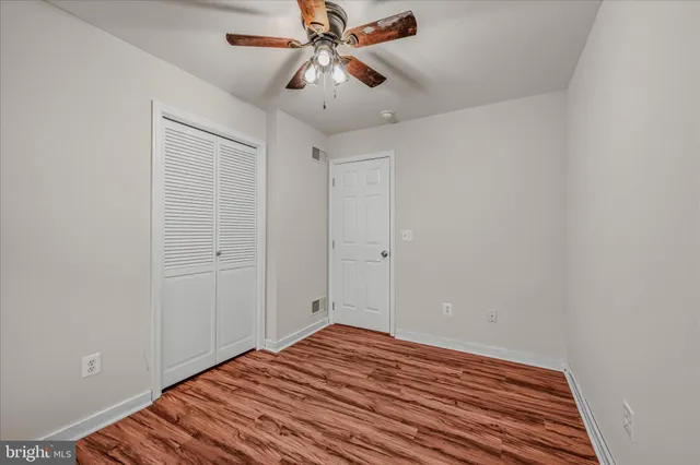 a view of a room with wooden floor and ceiling fan