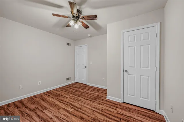 a view of a livingroom with wooden floor and a ceiling fan