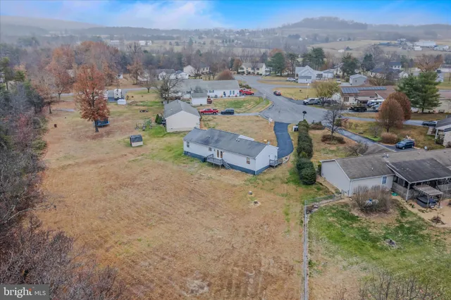 an aerial view of a house with swimming pool and mountains