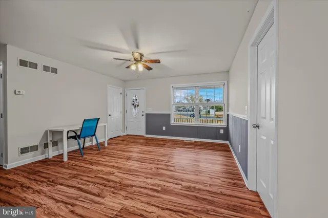 a view of a livingroom with a furniture wooden floor and a ceiling fan