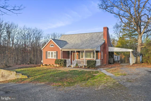 a front view of a house with a yard and trees