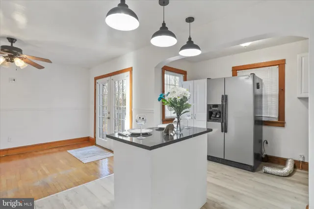 a kitchen with white cabinets and chandelier